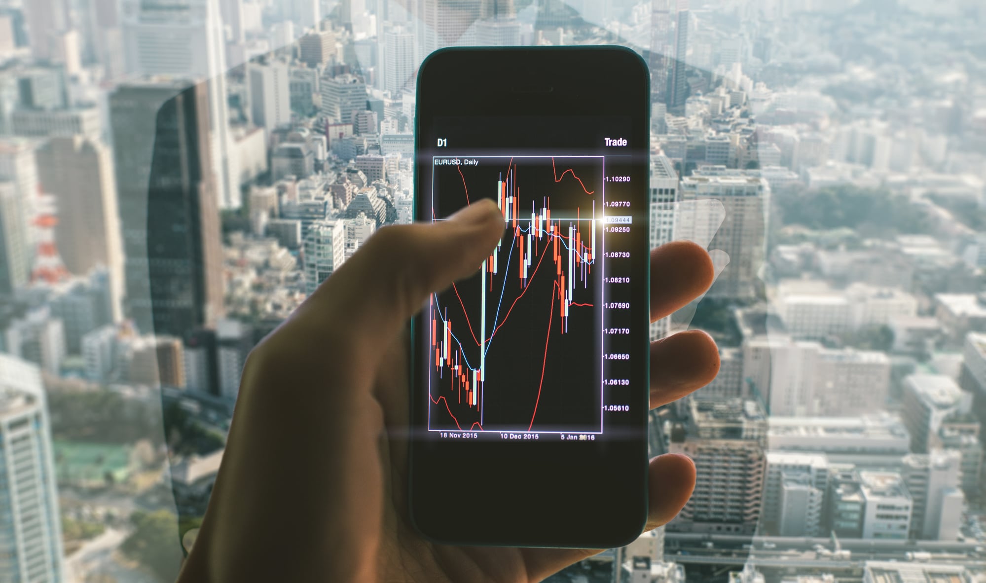 Close-up of a person’s hand holding a smartphone to track the performance of their online trading activity.