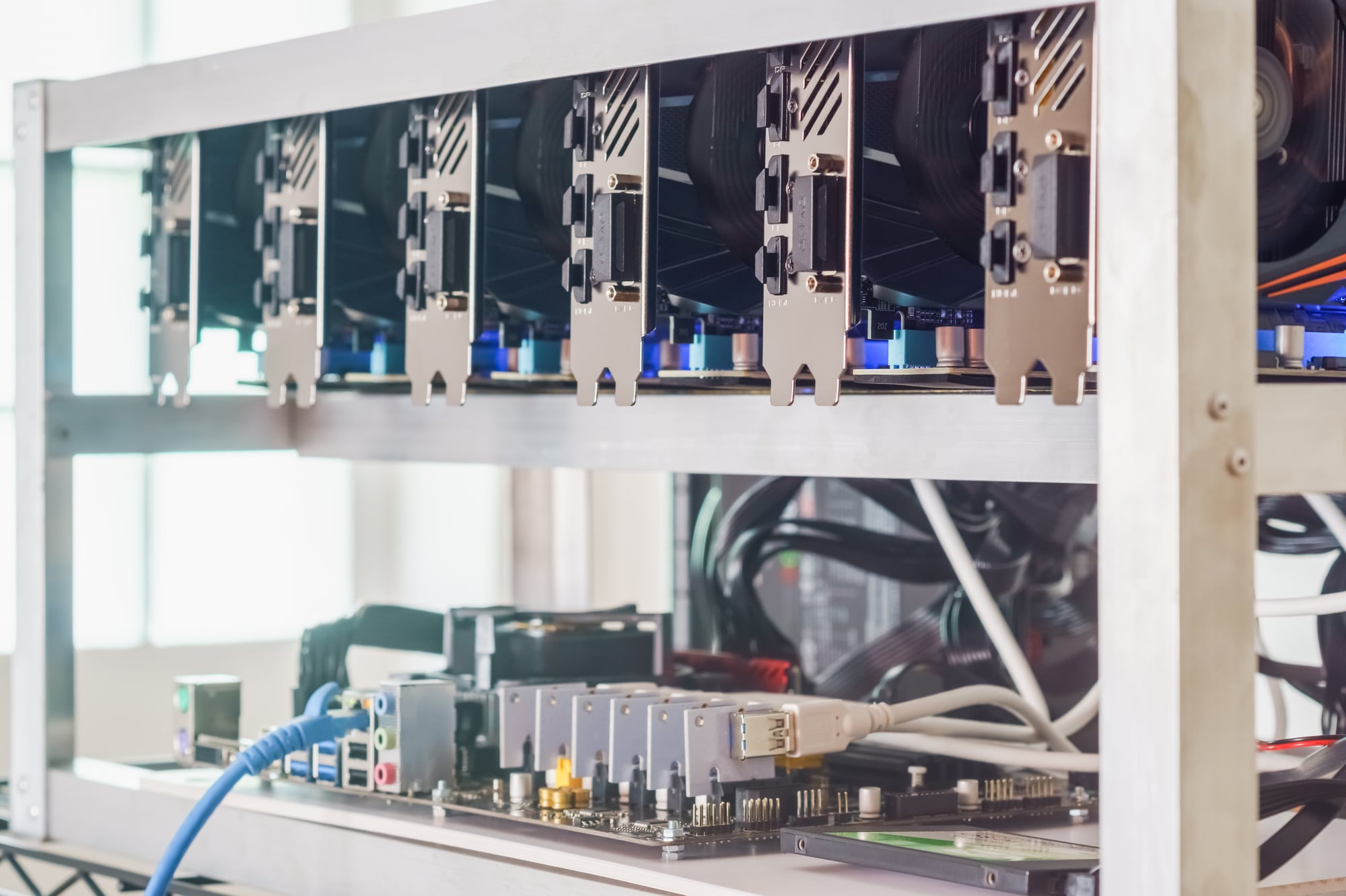 An array of GPUs on a metal shelf used for mining cryptocurrency.