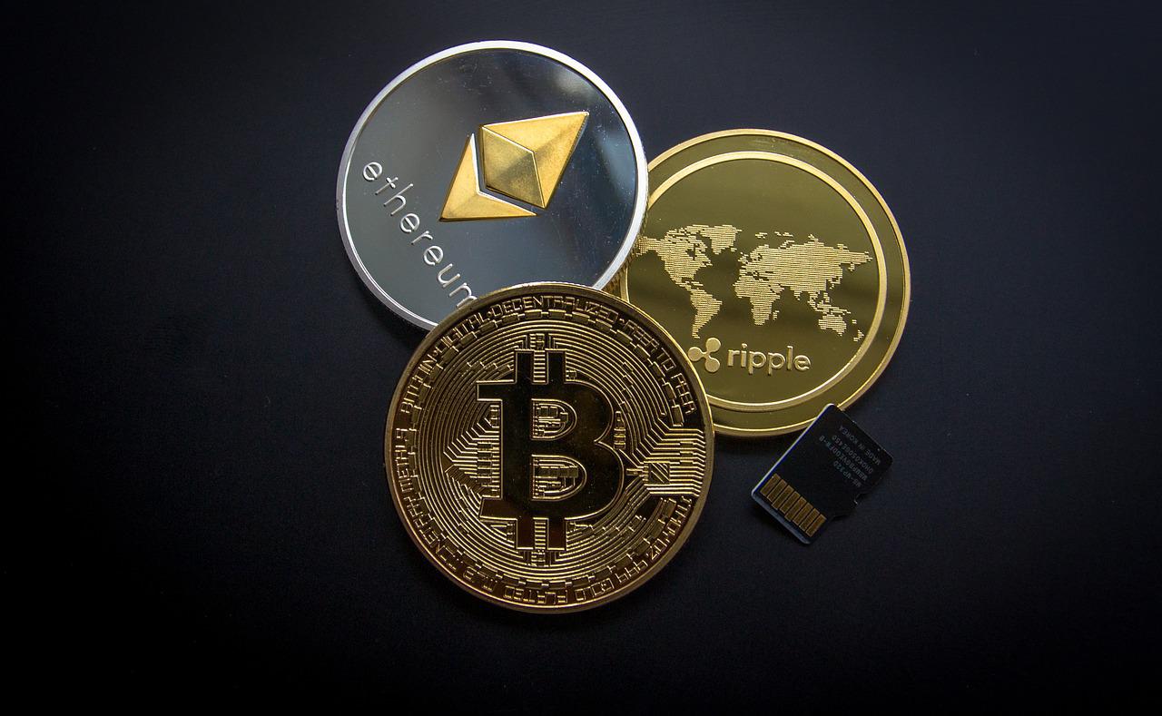 Close-up of various cryptocurrencies realized as tangible metal coins with their respective brand names and icons printed on the surfaces.