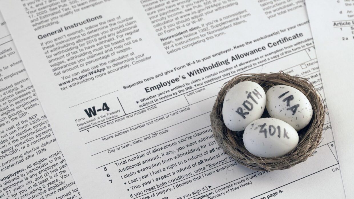 Three eggs labeled “Roth,” “IRA,” and “401k” resting in a bird’s nest atop a W-4 tax return certificate.