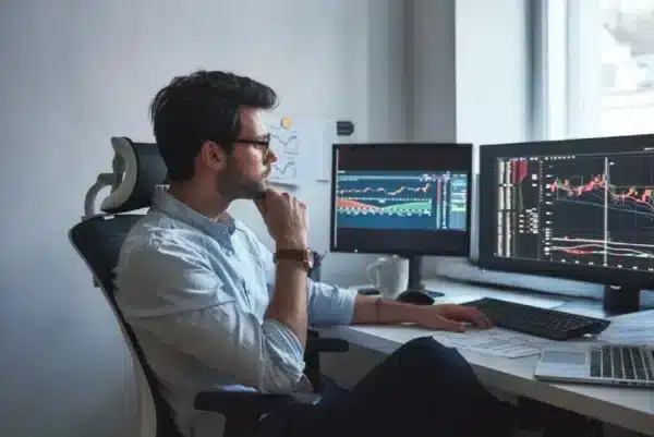A man sitting at a computer with images of the market.