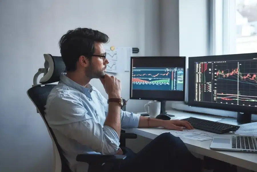A man sitting at a computer with images of the market.