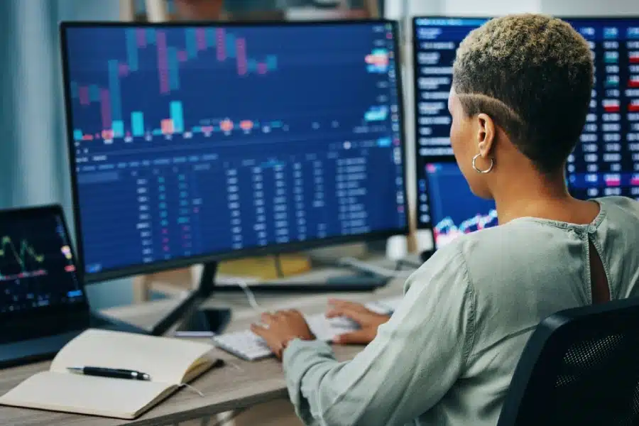 A woman trading at her computer.