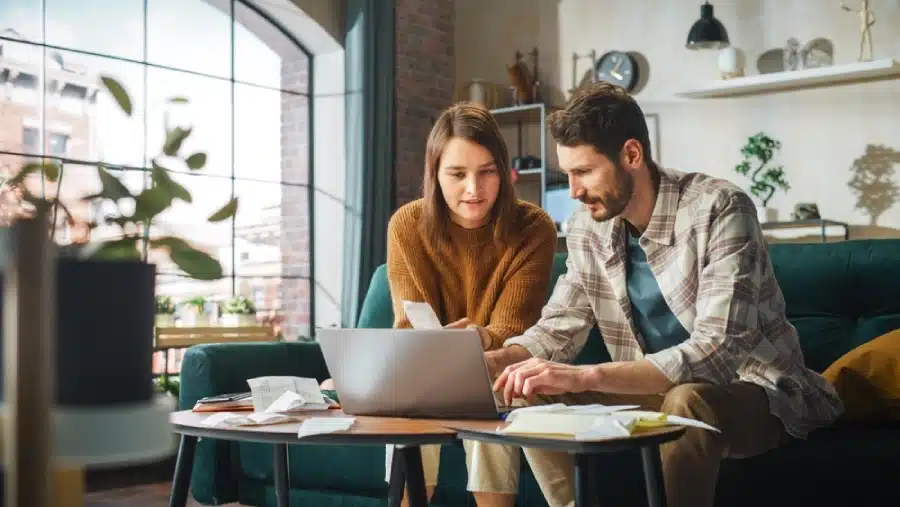 A couple sitting at their computer, looking at investments.
