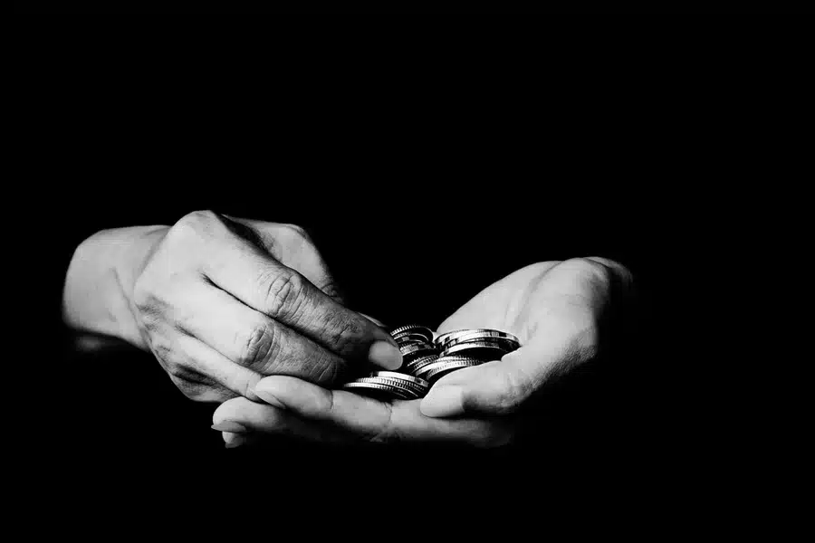 Hands holding silver coins.